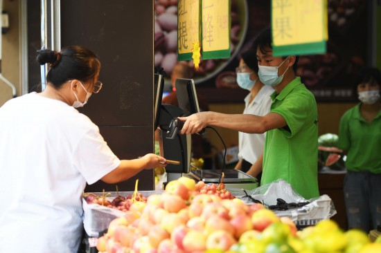 8月23日，市民在鄭州市金水區豐慶路一家水果店購物后結賬。